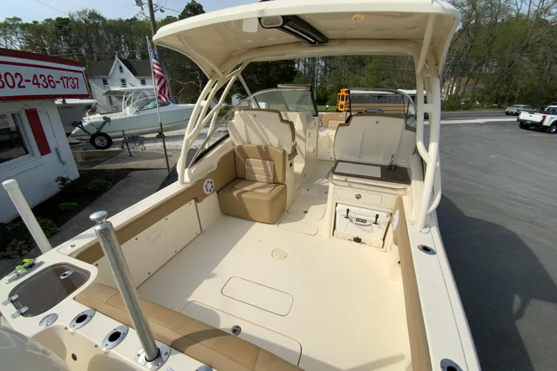 Slide: The Image of 2019 Scout 255 Dorado boat interior with seating and storage, parked outdoors. - 11