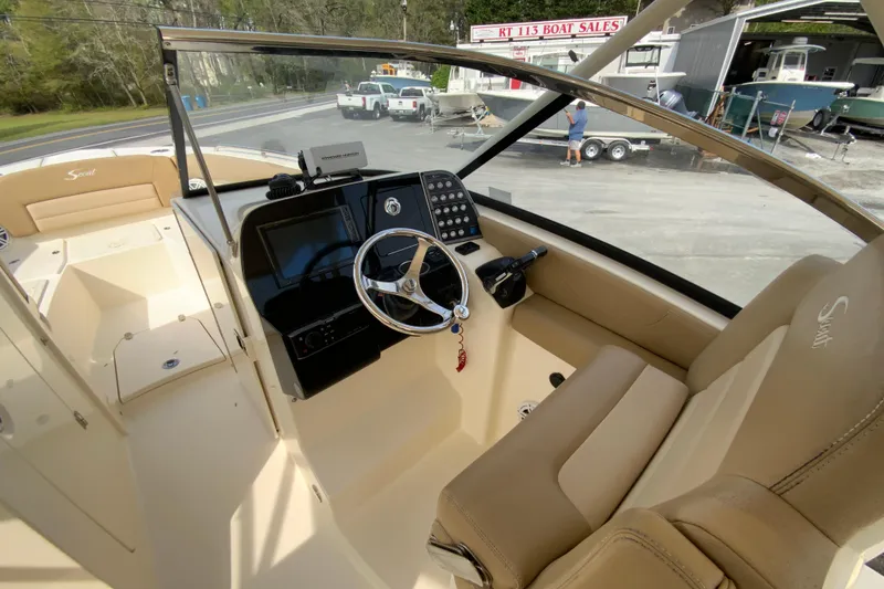 Slide: The Image of 2019 Scout 255 Dorado boat interior with steering wheel and dashboard at a boat sales lot. - 16