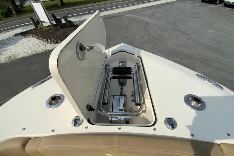 Slide: The Image of 2019 Scout 255 Dorado boat anchor compartment with open hatch, showcasing storage and hardware. - 24