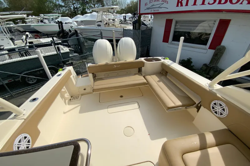 Slide: The Image of 2019 Scout 255 Dorado boat interior with seating and dual engines at a dealership. - 25
