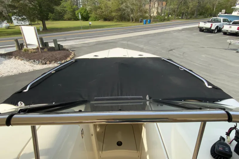 Slide: The Image of 2019 Scout 255 Dorado boat with black cover, parked on a driveway. - 32