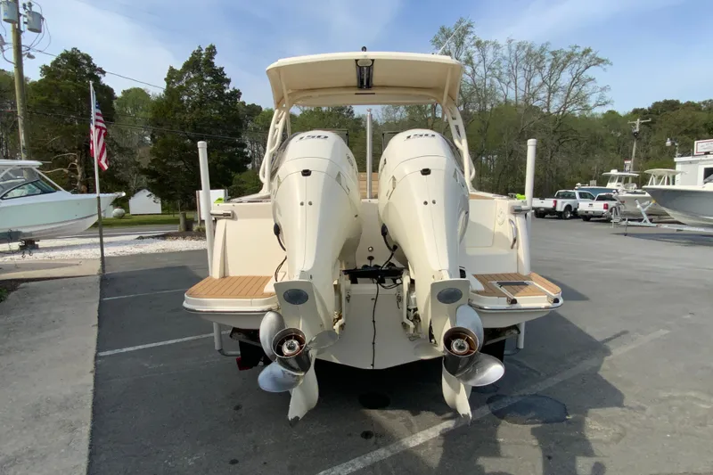 Slide: The Image of 2019 Scout 255 Dorado boat with dual outboard engines, parked outdoors. - 9