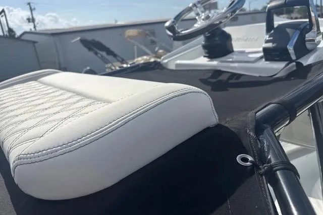 Slide: The Image of 2017 Yellowfin 26 Hybrid boat interior with white cushioned seating and steering wheel. - 11