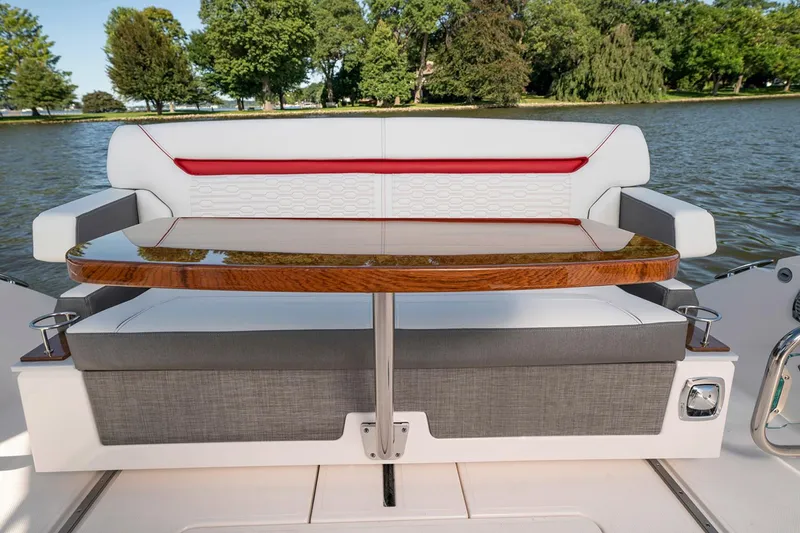 Slide: The Image of Manufacturer Provided Image: 2021 Tiara Sport 34 LS boat seating area with wooden table on a lake. - 15