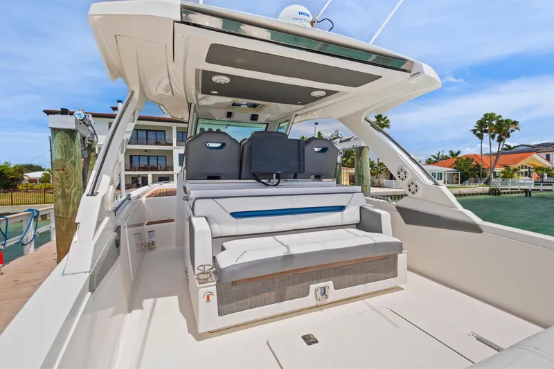 Slide: The Image of 2021 Tiara Sport 34 LS luxury boat interior at dockside, showcasing seating and helm. - 21