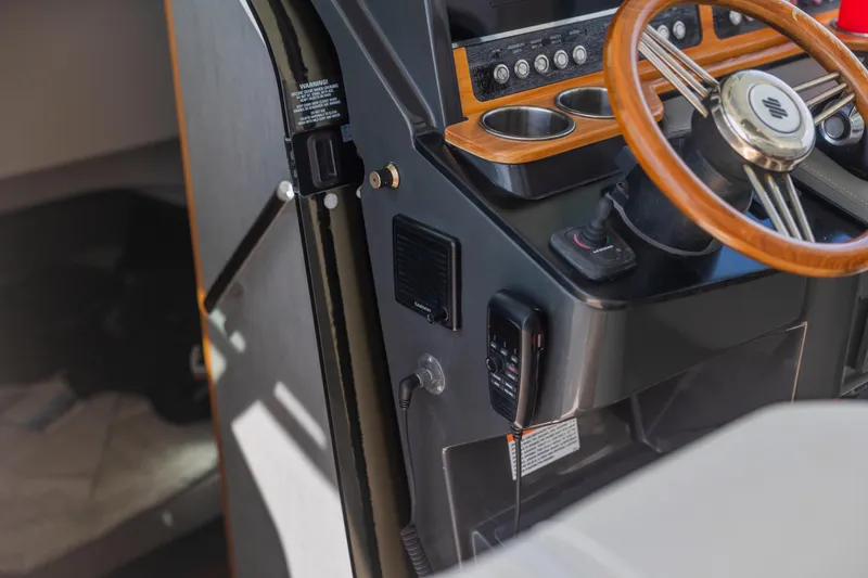 Slide: The Image of 2021 Tiara Sport 34 LS boat helm with wooden steering wheel and control panel. - 28