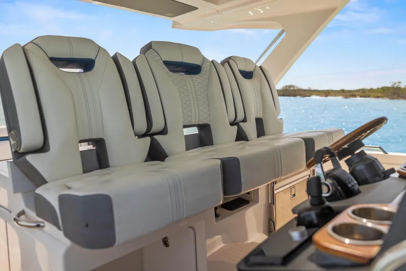 Slide: The Image of 2021 Tiara Sport 34 LS boat interior with luxurious seating and helm, overlooking the ocean. - 32