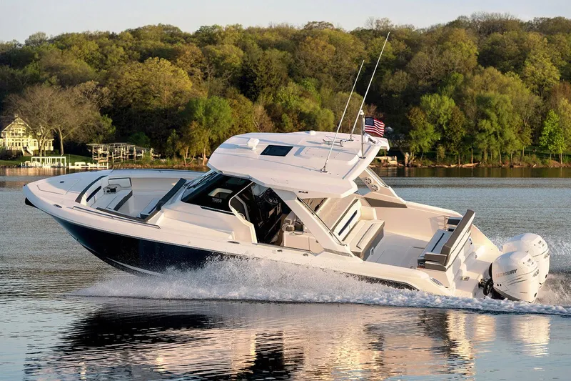 Slide: The Image of Manufacturer Provided Image: 2021 Tiara Sport 34 LS boat cruising on a lake with lush green trees in the background. - 4