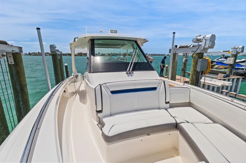 Slide: The Image of 2021 Tiara Sport 34 LS boat docked, featuring spacious seating and sleek design. - 42