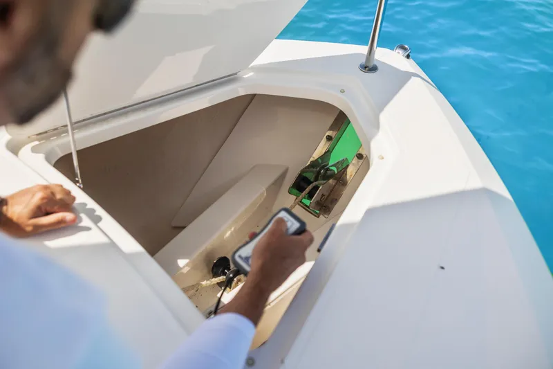 Slide: The Image of Man operating anchor compartment on 2021 Tiara Sport 34 LS boat. - 44