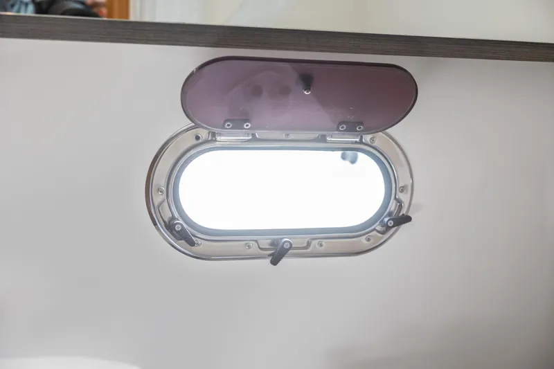 Slide: The Image of Porthole window on 2021 Tiara Sport 34 LS boat, open for ventilation. - 51