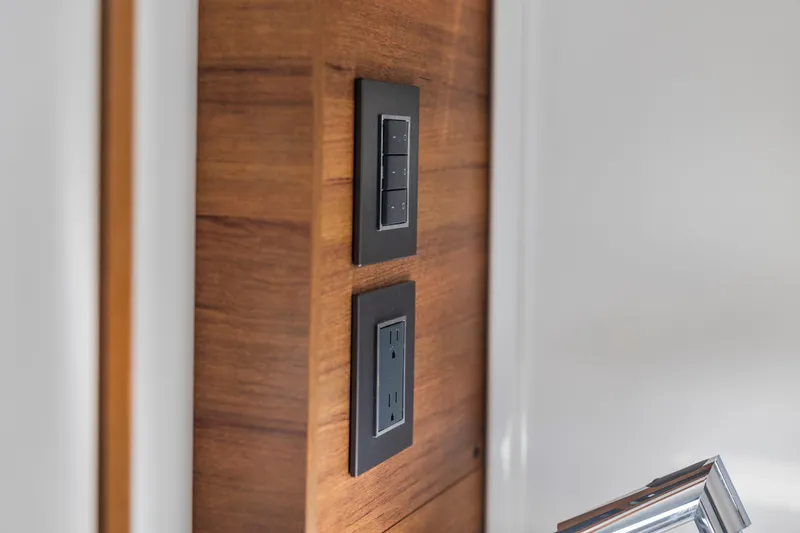 Slide: The Image of Wall-mounted switches and outlet on Tiara Sport 34 LS, 2021 model, with wood paneling. - 55