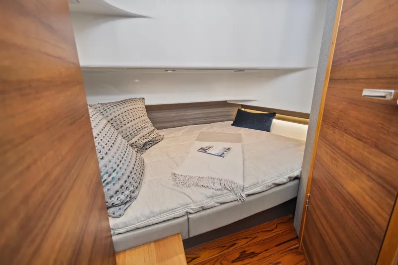 Slide: The Image of Cozy cabin interior of 2021 Tiara Sport 34 LS with plush bedding and wooden accents. - 56