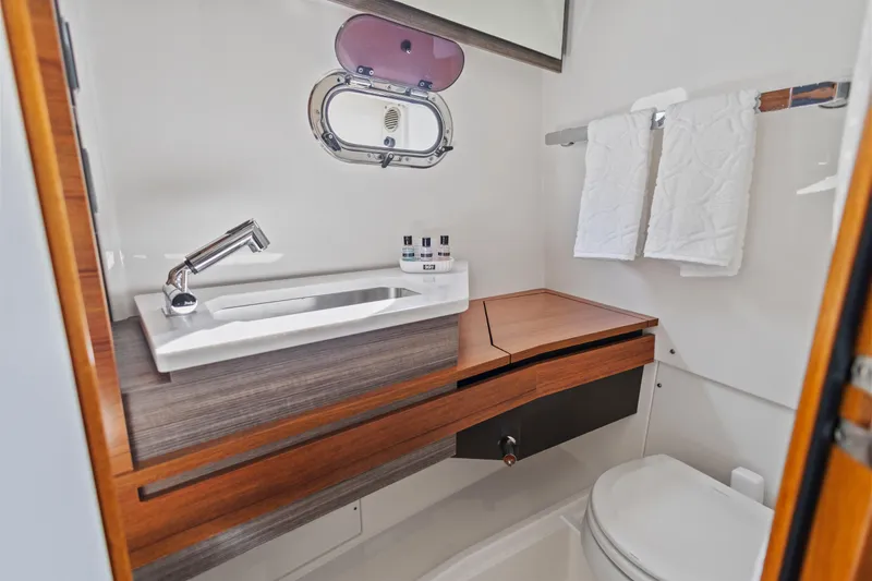 Slide: The Image of Luxurious bathroom in 2021 Tiara Sport 34 LS boat with modern fixtures and wooden accents. - 58
