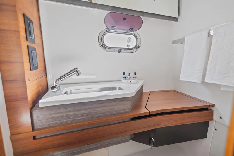 Slide: The Image of 2021 Tiara Sport 34 LS yacht bathroom with modern sink and wooden accents. - 59