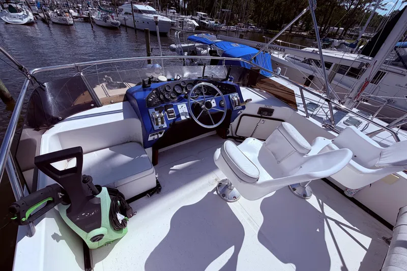 Slide: The Image of 1987 Sea Ray 340 Sedan Bridge cockpit with steering wheel, controls, and seating at marina. - 11