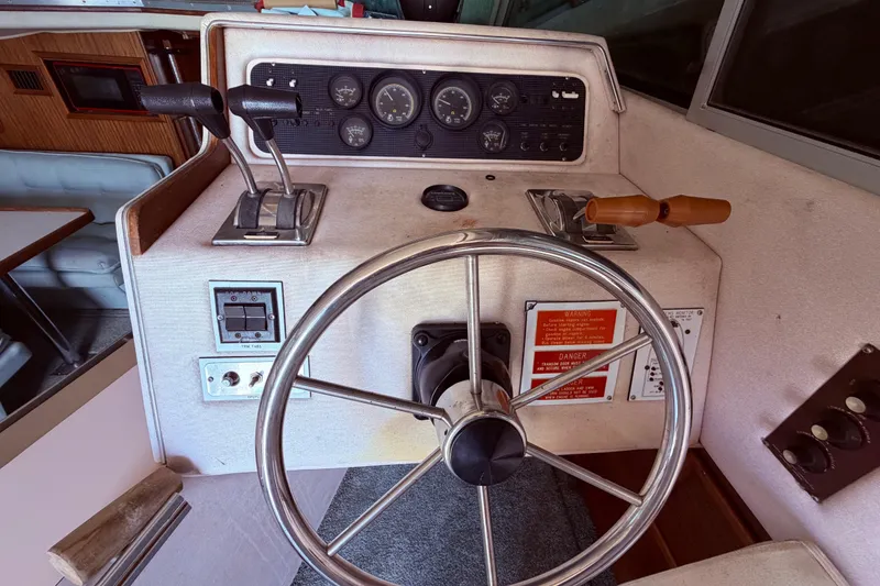 Slide: The Image of 1987 Sea Ray 340 Sedan Bridge helm with steering wheel and control panel. - 33