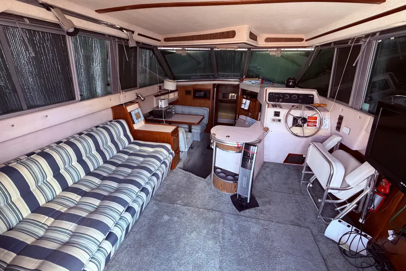 Slide: The Image of Interior of 1987 Sea Ray 340 Sedan Bridge with striped sofa and helm station. - 35