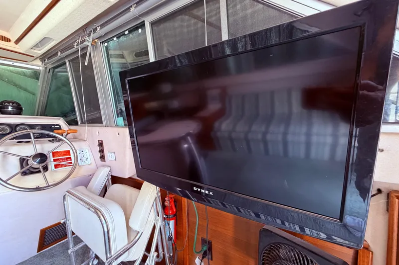 Slide: The Image of Interior of 1987 Sea Ray 340 Sedan Bridge with steering wheel and mounted TV. - 37