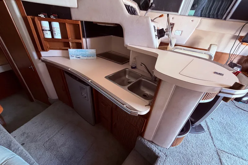 Slide: The Image of 1987 Sea Ray 340 Sedan Bridge galley nterior with kitchenette, sink, and storage cabinets. - 39