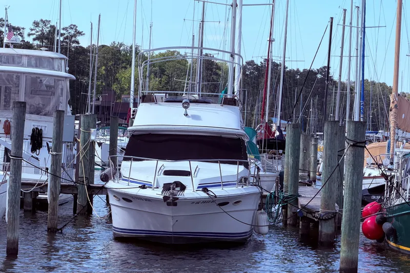 Slide: The Image of 1987 Sea Ray 340 Sedan Bridge docked in a marina, surrounded by other boats. - 4