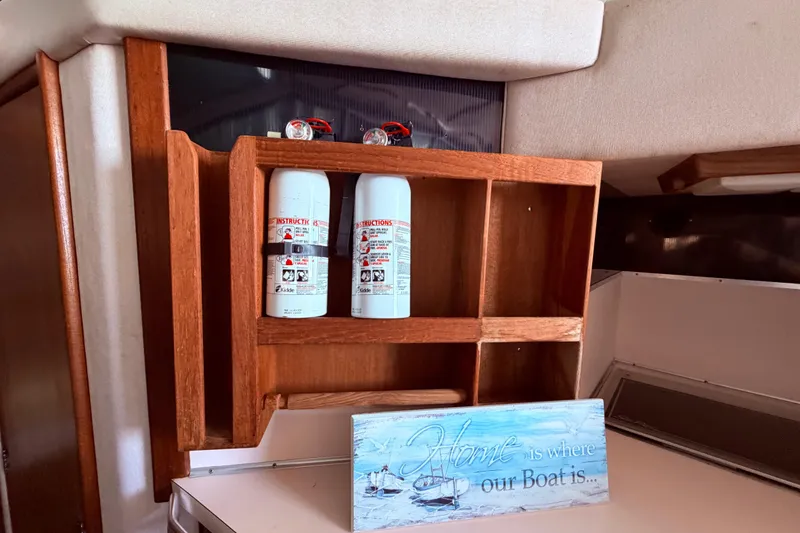 Slide: The Image of Wooden shelf with fire extinguishers and a nautical-themed sign on a 1987 Sea Ray 340 Sedan Bridge. - 40
