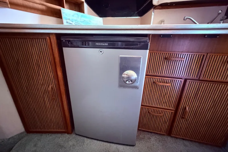 Slide: The Image of Frigidaire refrigerator in 1987 Sea Ray 340 Sedan Bridge yacht kitchen with wooden cabinetry. - 41