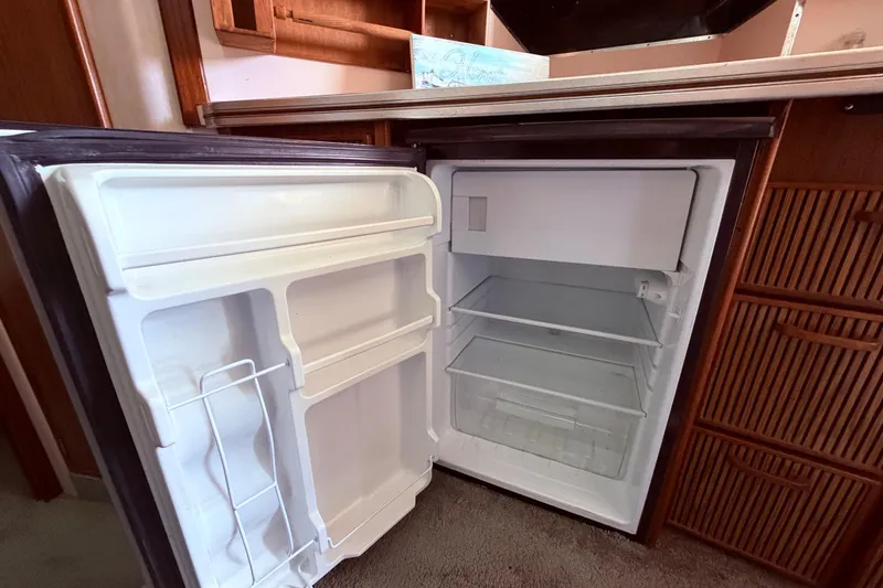 Slide: The Image of Open refrigerator inside 1987 Sea Ray 340 Sedan Bridge yacht, showcasing interior storage space. - 42