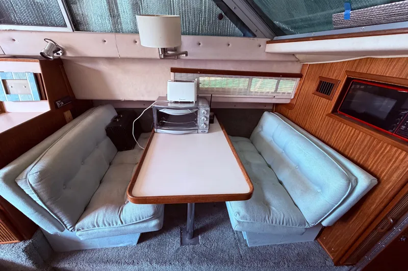 Slide: The Image of Interior of 1987 Sea Ray 340 Sedan Bridge with dining area and appliances. - 49