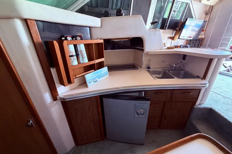 Slide: The Image of 1987 Sea Ray 340 Sedan Bridge interior kitchen with sink, fridge and spacious cabinets / shelving - 50