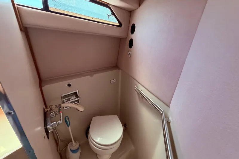 Slide: The Image of 1987 Sea Ray 340 Sedan Bridge bathroom with Jabsco electric toilet and wet head shower area - 60