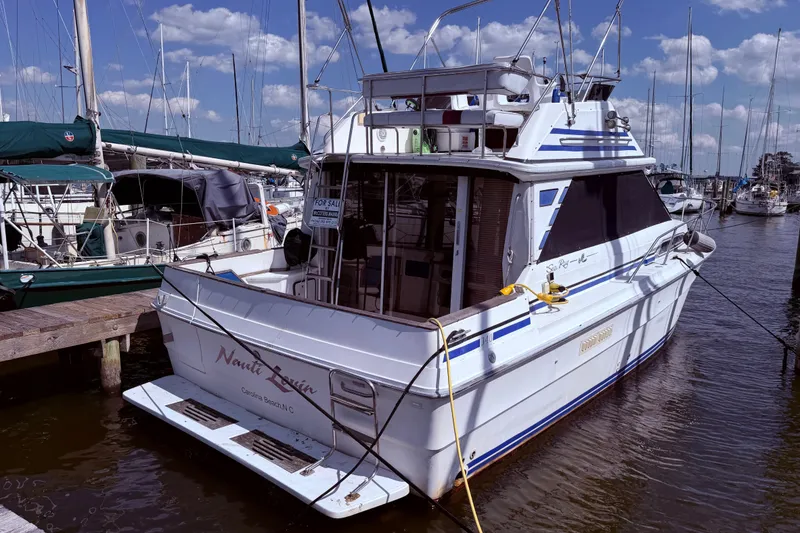 Slide: The Image of 1987 Sea Ray 340 Sedan Bridge docked at marina, for sale sign visible. - 8