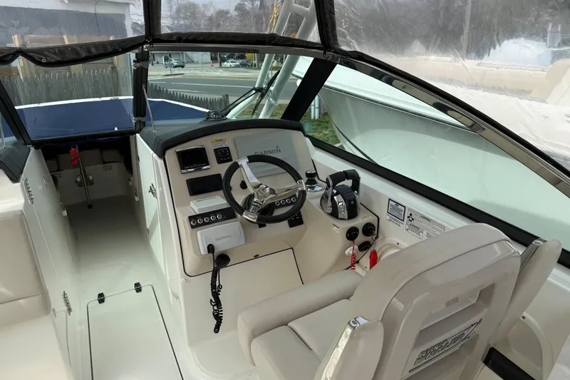 Slide: The Image of 2015 Boston Whaler 270 Vantage boat cockpit with steering wheel and navigation controls. - 5