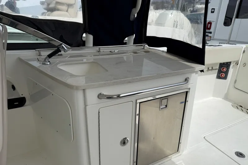 Slide: The Image of 2015 Boston Whaler 270 Vantage boat interior with sink and storage area. - 8