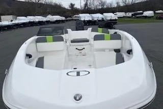Slide: The Image of 2024 Tahoe T16 boat with white and green seating, parked outdoors. - 5