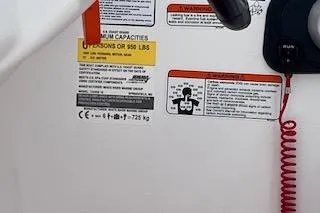 Slide: The Image of 2024 Tahoe T16 boat safety labels and controls with red coiled cord. - 7