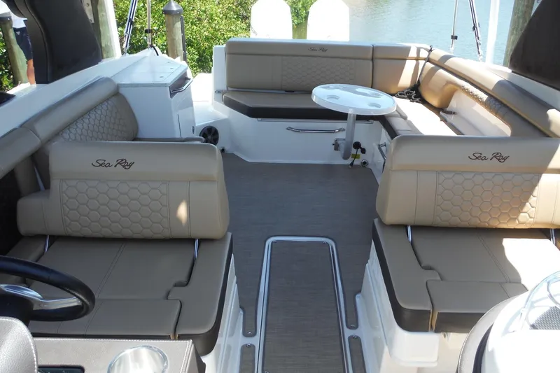 Slide: The Image of 2019 Sea Ray SDX 290 Outboard boat interior with beige seating and a small table. - 15