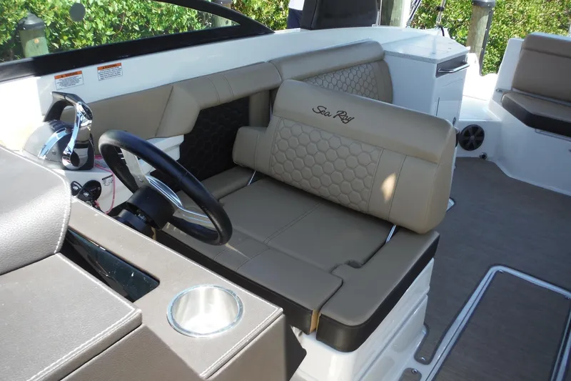 Slide: The Image of 2019 Sea Ray SDX 290 Outboard interior with beige seating and steering wheel. - 16