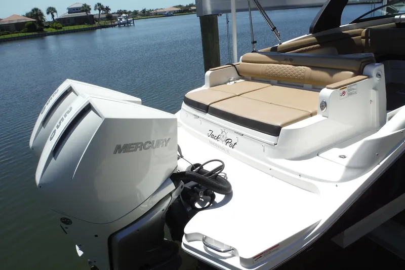 Slide: The Image of 2019 Sea Ray SDX 290 Outboard with twin Mercury engines, docked by a serene waterfront. - 2