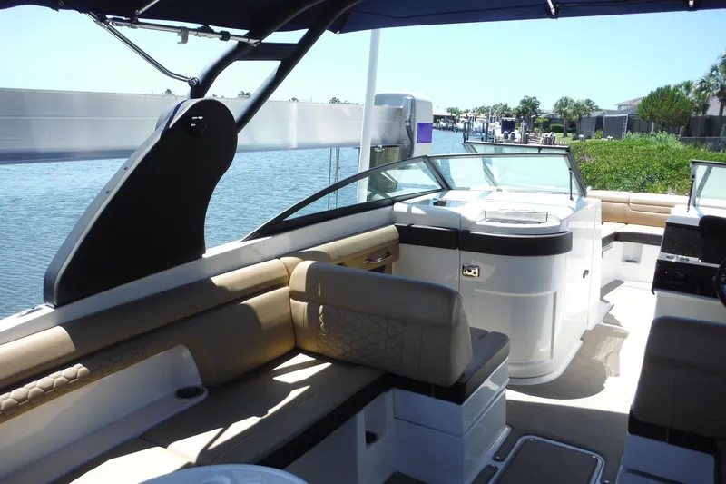 Slide: The Image of 2019 Sea Ray SDX 290 Outboard boat interior with seating and helm, docked by water. - 22