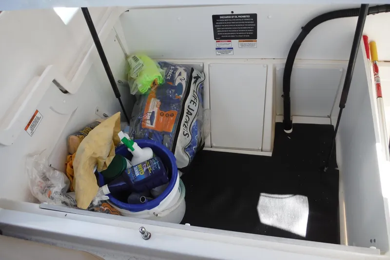 Slide: The Image of Storage compartment of 2019 Sea Ray SDX 290 Outboard with life jackets and cleaning supplies. - 23