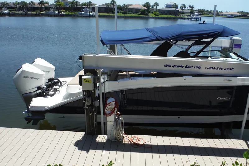 Slide: The Image of 2019 Sea Ray SDX 290 Outboard docked with blue canopy and dual Mercury engines. - 6