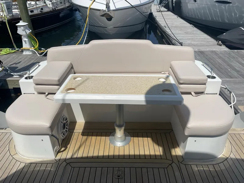 Slide: The Image of 2012 Cruisers Yachts 48 Cantius deck with beige seating and table, docked at marina. - 7