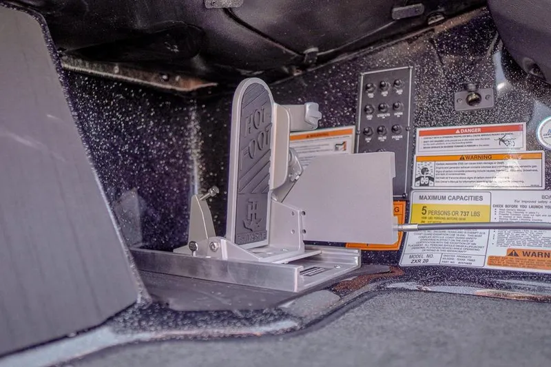 Slide: The Image of 2026 Skeeter ZXR20 SE boat foot pedal and control panel with safety labels. - 11
