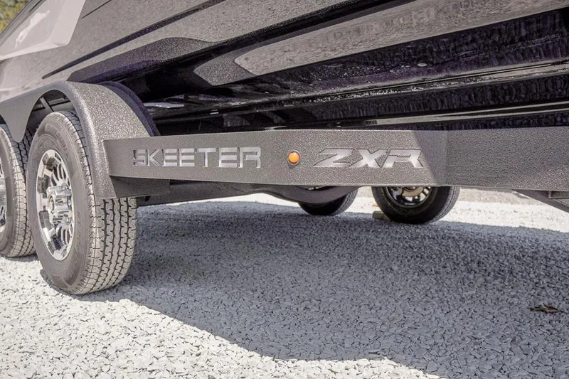 Slide: The Image of 2026 Skeeter ZXR20 SE trailer with dual wheels on gravel surface. - 18