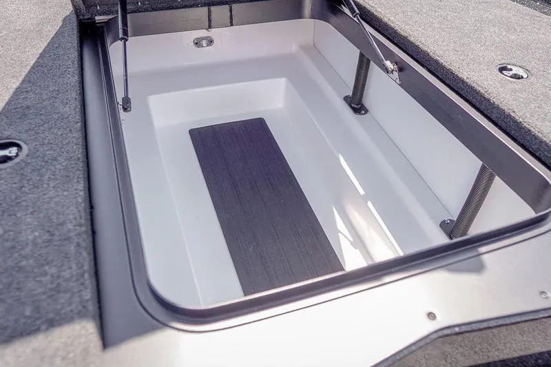 Slide: The Image of Open storage compartment in 2026 Skeeter ZXR20 SE boat, featuring hydraulic lift supports. - 26