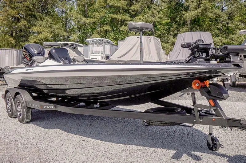 Slide: The Image of 2026 Skeeter ZXR20 SE boat on trailer, parked outdoors, surrounded by trees and other boats. - 5