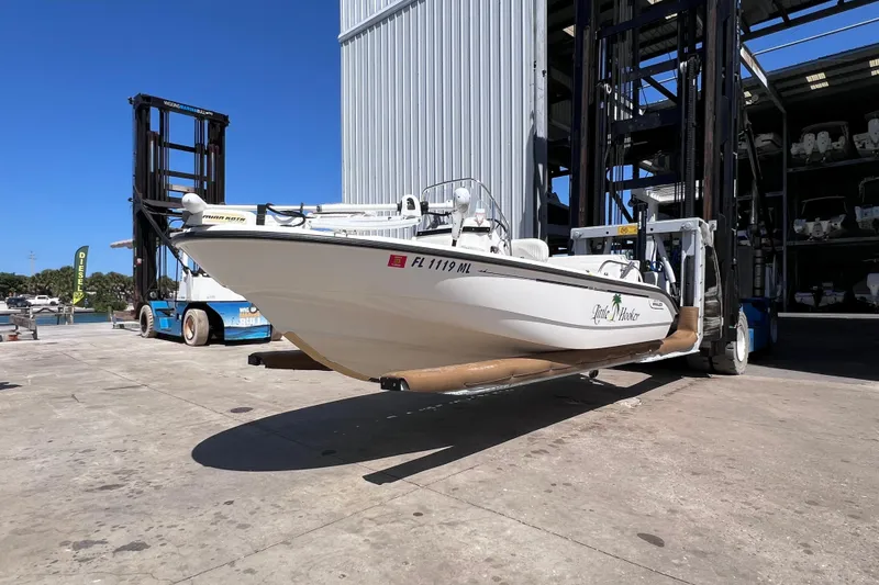 Slide: The Image of 2004 Boston Whaler 180 Dauntless boat on forklift at marina storage facility. - 2