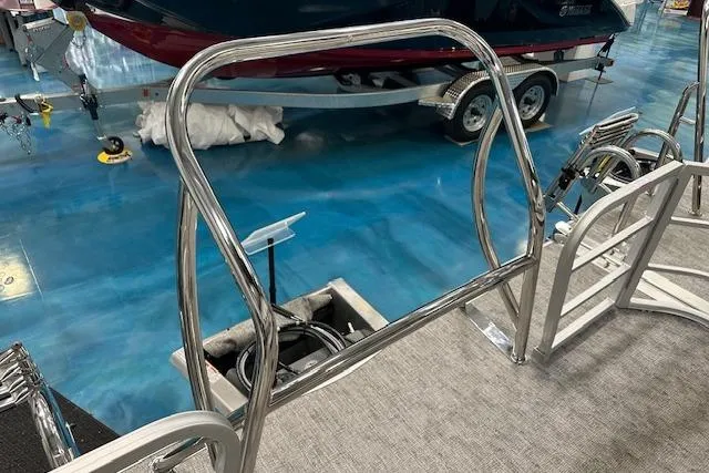 Slide: The Image of 2025 Berkshire 24UL LE B pontoon boat with chrome railings in a showroom. - 8