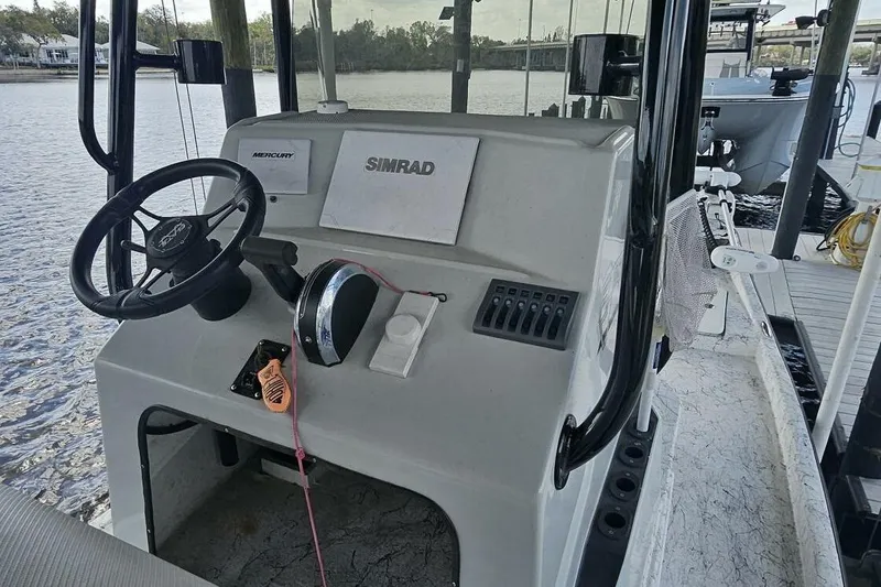 Slide: The Image of 2021 Flats Cat 21' boat console with steering wheel and controls on a dock. - 14